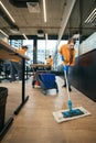 Team cleaning ladies works in coworking area, women use mop, buckets, rags Royalty Free Stock Photo