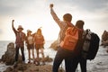 Team of climbers man and woman hiker hiking mountain climbing success stand at the cliff with backpacks on mountain top over.