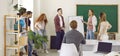 Team of college students presents their project together in classroom near whiteboard. Royalty Free Stock Photo