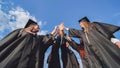 Team of college or university students celebrating graduation. Group of happy successful graduates in academic hats and