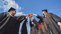 Team of college or university students celebrating graduation. Group of happy successful graduates in academic hats and