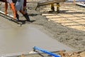 A team of concrete workers  lay wet mud over a new driveway site Royalty Free Stock Photo