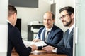 Group of confident successful business people reviewing and signing a contract to seal the deal at business meeting in Royalty Free Stock Photo