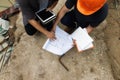 Team of construction workers discussing project details with blueprint in construction site Royalty Free Stock Photo