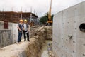 Team of construction workers discussing project details with blueprint in construction site Royalty Free Stock Photo