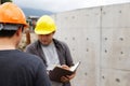 Team of construction workers discussing project details with blueprint in construction site Royalty Free Stock Photo