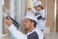 Team construction workers installing window in house