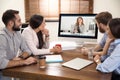 Team of coworkers having video chat with boss in office