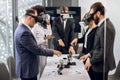 Team of creative multiracial colleagues, designers, architect in formal wear, standing around the table and using vr Royalty Free Stock Photo