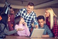 Team of creative people looking at colleague showing project plan on his laptop. Royalty Free Stock Photo