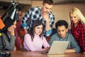 Team of creative people looking at colleague showing project plan on his laptop. Royalty Free Stock Photo