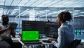 Team of developers in server hub using green screen laptop