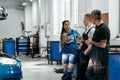 Team of diverse mechanics in uniform, two men and a woman talking and eating sandwiches, while having a break at auto Royalty Free Stock Photo