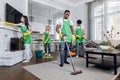 Team of diverse professional hardworking mixed race cleaners from cleaning service, working together in modern luxury