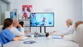 Team of doctors having video conference sitting at desk in hospital meeting room Royalty Free Stock Photo