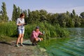 Team of ecologists take samples of green algae on bank of polluted river