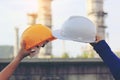 Team engineer hand holding security helmet on oil refinery background