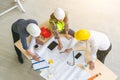 Team of engineers and architects working, planing, measuring layout of building blueprints in construction site. top view