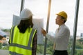 Team of Engineers architects working and standing around table working on blueprint at construction plans. Engineers discussing