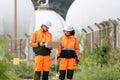 Team of Engineers Conducting Operations at Oil Storage Field Industrial Site, Industrial Workers Communicating and Using Laptop at Royalty Free Stock Photo