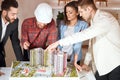 Team of engineers styding a model of building complex at meeting Royalty Free Stock Photo