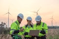 Team of engineers working and using a computer laptop on site in wind turbine farm, Wind turbines generate clean energy source, Royalty Free Stock Photo