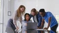 Team of excited diverse colleagues looking at laptop screen celebrating successful sales