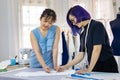 Team of fashionable freelance dressmakers making adjustment on muslin for new custom made dress while working in artistic workshop Royalty Free Stock Photo