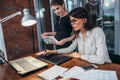 Team of female interior designer drawing a new project using graphic tablet, laptop and color palette sitting at desk in Royalty Free Stock Photo