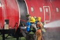 Team of firefighters entering training aircraft.