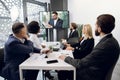 Team of five focused multiethnical businesspeople looking at screen, having video conference in modern office, with Royalty Free Stock Photo