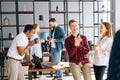 Team of five young cheerful diverse multiethnic coworkers having fun enjoy communication at group meeting during coffee Royalty Free Stock Photo