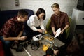 Team of four creative engineers working with virtual reality, young woman testing VR glasses or goggles sitting in the office room