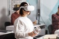 Team of four creative engineers working with virtual reality, young woman testing VR glasses or goggles sitting in the office room Royalty Free Stock Photo