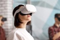 Team of four creative engineers working with virtual reality, young woman testing VR glasses or goggles sitting in the office room Royalty Free Stock Photo