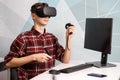 Team of four creative engineers working with virtual reality, young woman testing VR glasses or goggles sitting in the office room Royalty Free Stock Photo