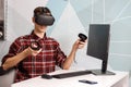 Team of four creative engineers working with virtual reality, young woman testing VR glasses or goggles sitting in the office room Royalty Free Stock Photo