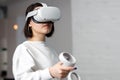 Team of four creative engineers working with virtual reality, young woman testing VR glasses or goggles sitting in the office room Royalty Free Stock Photo