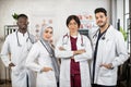 Team of four female and male multiracial doctors posing indoors