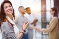 a team of four with a woman leader in the foreground stands in a modern office Royalty Free Stock Photo