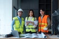 Team of happy confiden engineers wearing safety hard hat and vest standing at site work looking at camera Royalty Free Stock Photo