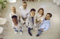 Team of happy multiracial business colleagues smiling together looking up in office. Royalty Free Stock Photo