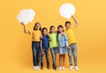 Team of happy school children showing speech balloon paper cards Royalty Free Stock Photo