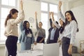 Group of happy women raising hands, voting for a good idea in a corporate meeting Royalty Free Stock Photo