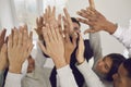 Team of happy young mixed-race business people raising their hands up in the air