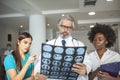 Team of healthcare professionals looking x-ray of the patient`s lungs. Male and female doctor looking at lungs x-ray in hospital