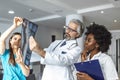 Team of healthcare professionals looking x-ray of the patient`s lungs. Male and female doctor looking at lungs x-ray in hospital