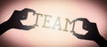 Team - human hands holding black silhouette word Royalty Free Stock Photo