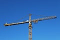 Team of installers stands on counterweight jib yellow tower crane.