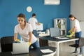 Team of janitors cleaning office